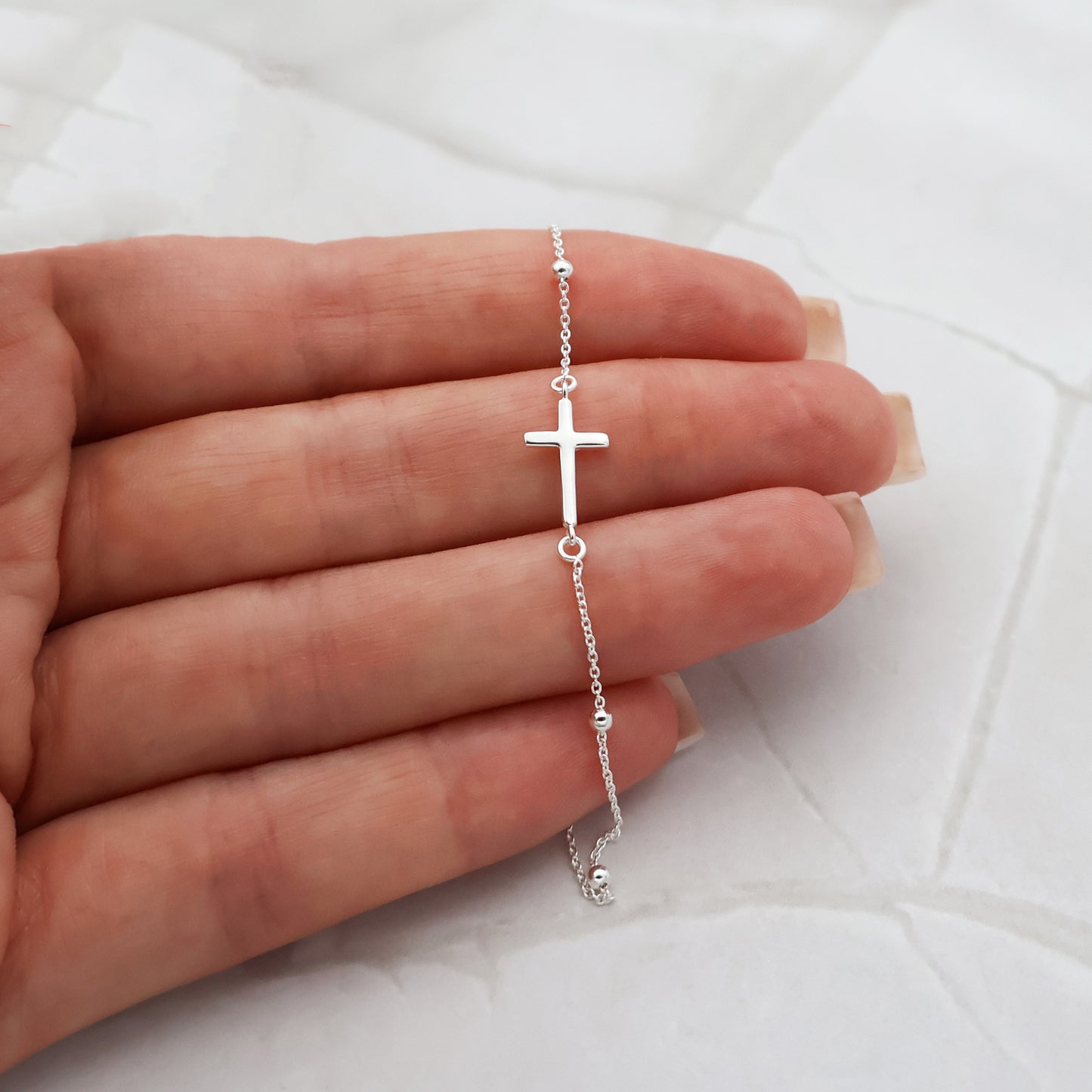 Pulsera con cuentas de plata y colgante de cruz fija