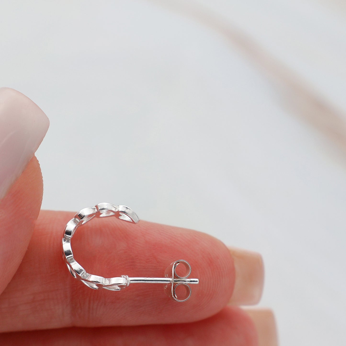 Stud earrings with hearts lined up in a semicircle shape