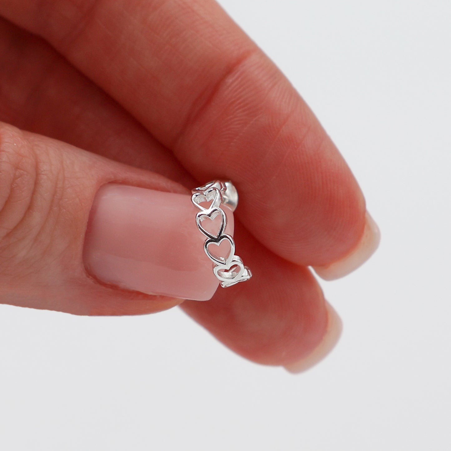 Stud earrings with hearts lined up in a semicircle shape