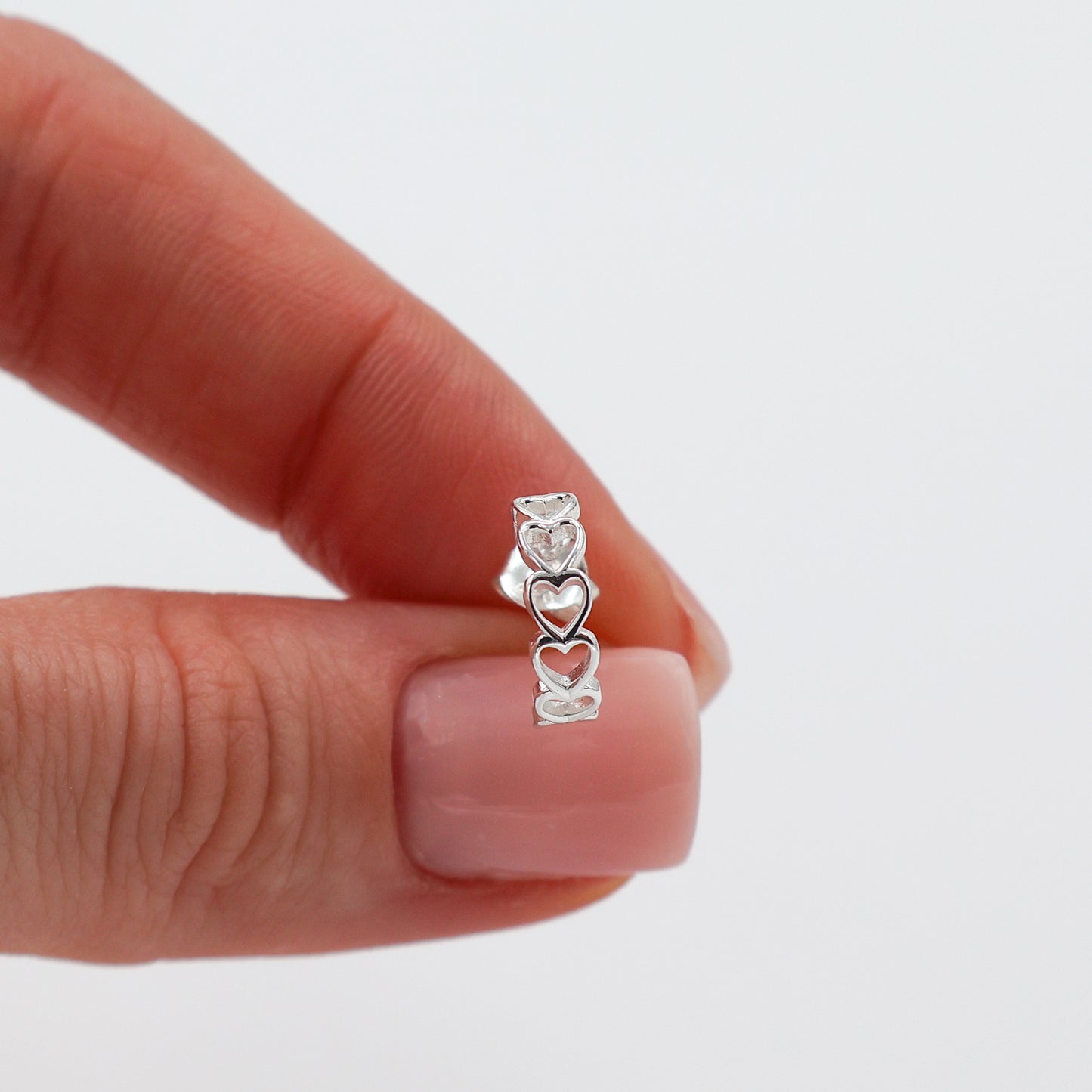 Stud earrings with hearts lined up in a semicircle shape