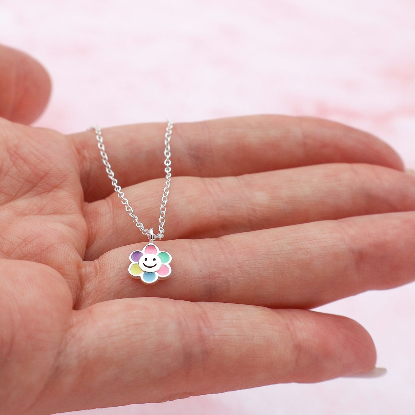 Necklace featuring a smiling flower pendant with multicolored petals