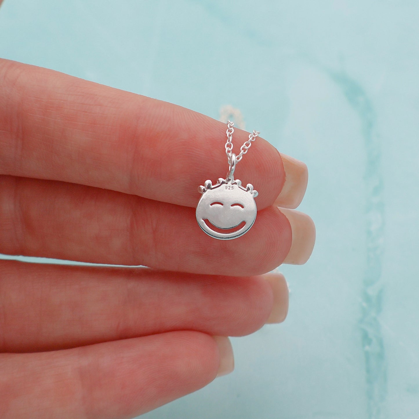 Necklace with a smiling face pendant and a crown with 3 white daisies