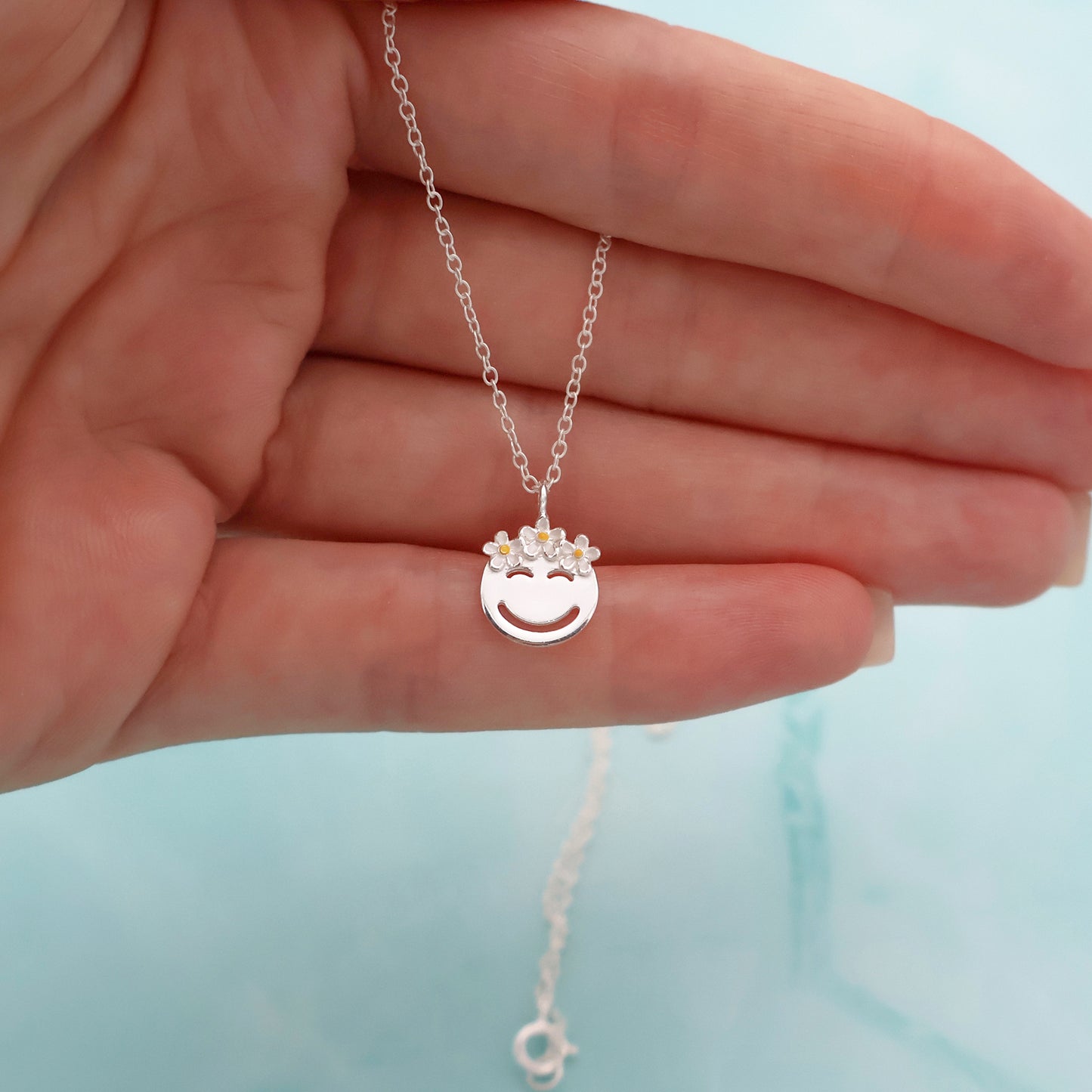 Necklace with a smiling face pendant and a crown with 3 white daisies