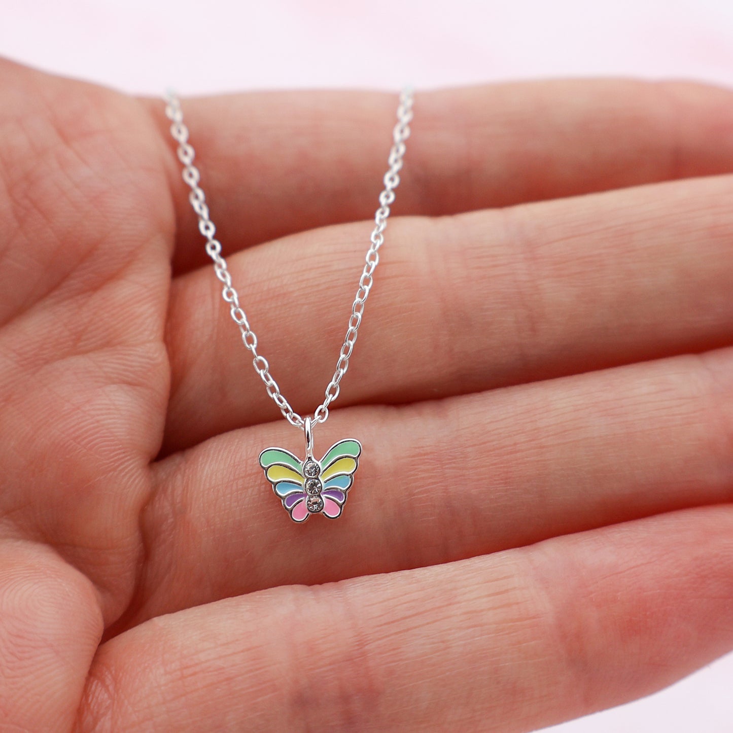 Necklace with a butterfly pendant featuring colorful wings and centrally placed crystals