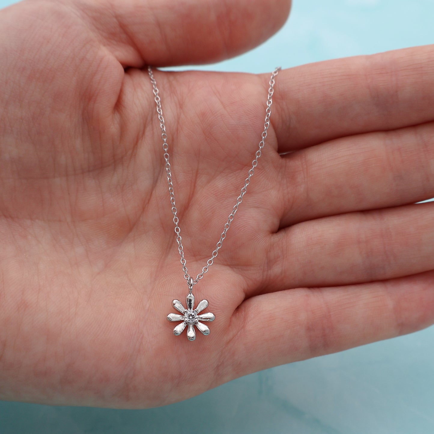 Necklace with a platinum-coated flower pendant and a central zirconia stone