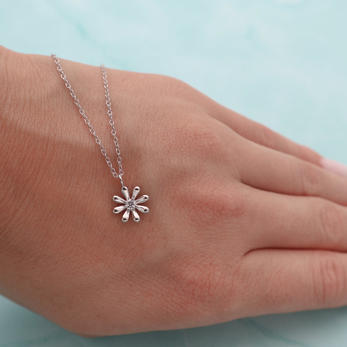 Necklace with a platinum-coated flower pendant and a central zirconia stone