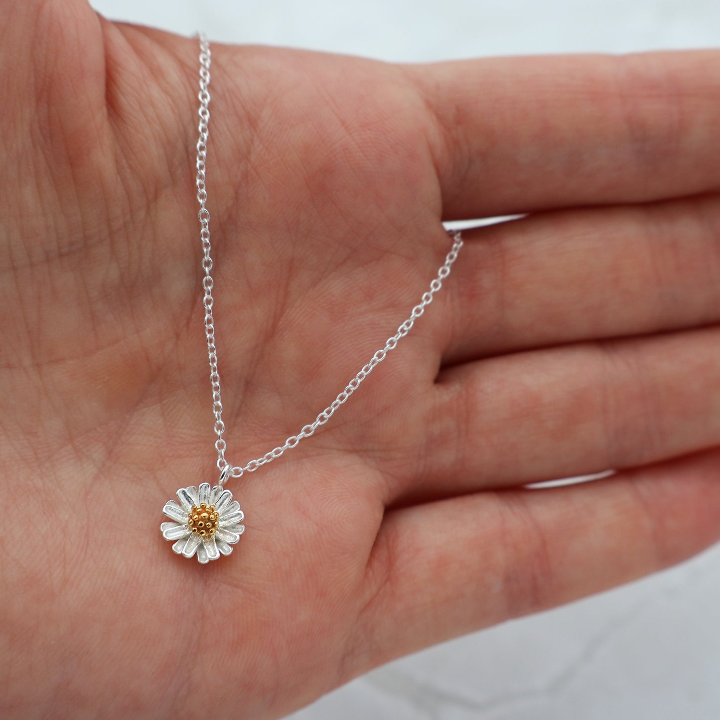 Necklace with a daisy pendant and a golden pistil